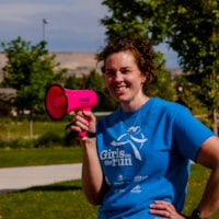 A Girls on the Run is smiling at the camera wearing a blue program shirt